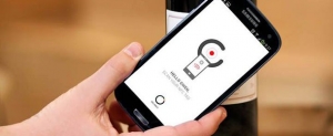 Un cliente fa &quot;tap&quot; con il cellulare su una bottiglia di Château Le Pin